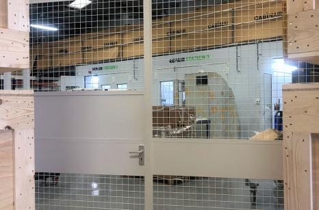 Large double door with service hatch divides workshop area from corridor