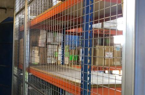 MRI scanner parts are stored on shelves in a lockable mesh cage